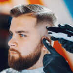 Stylish man sitting in a barbershop with an impeccable beard style.